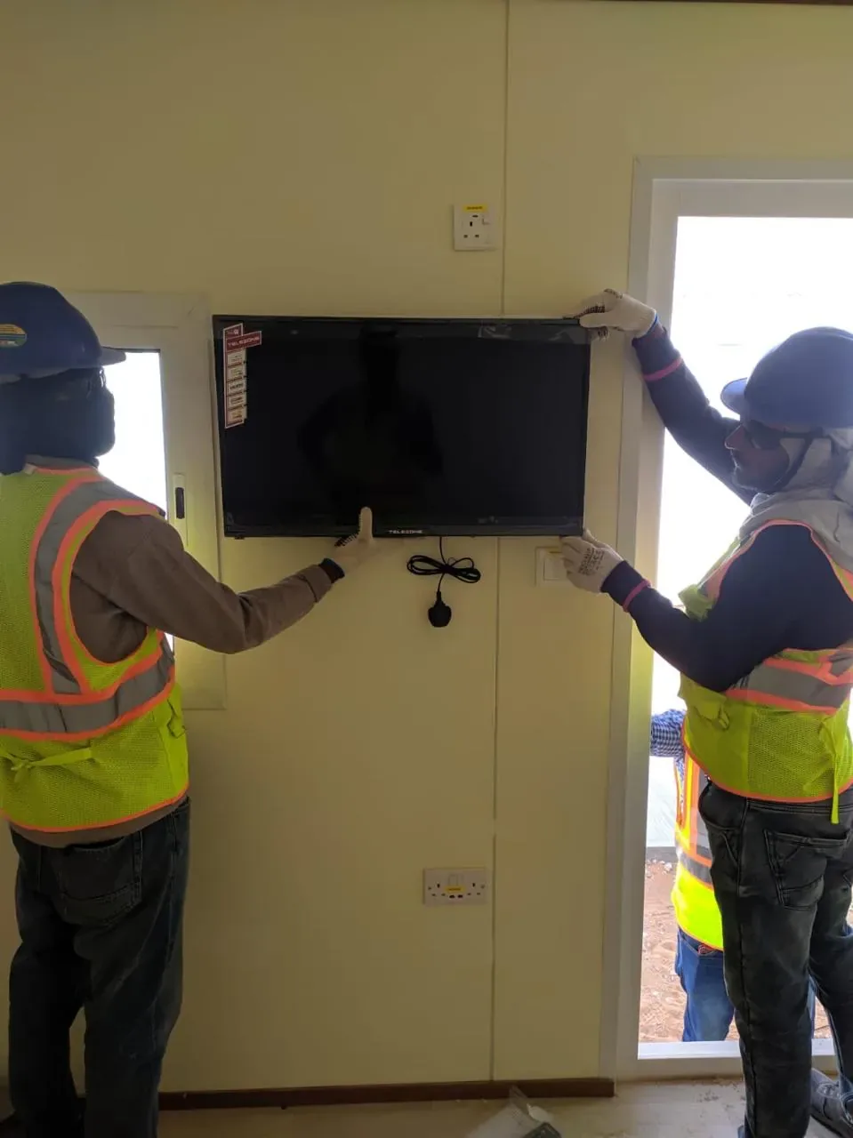 Dammam hotel and facility integration example showing smart TV installation inside labour camp accommodation rooms for the Aramco JGC project
